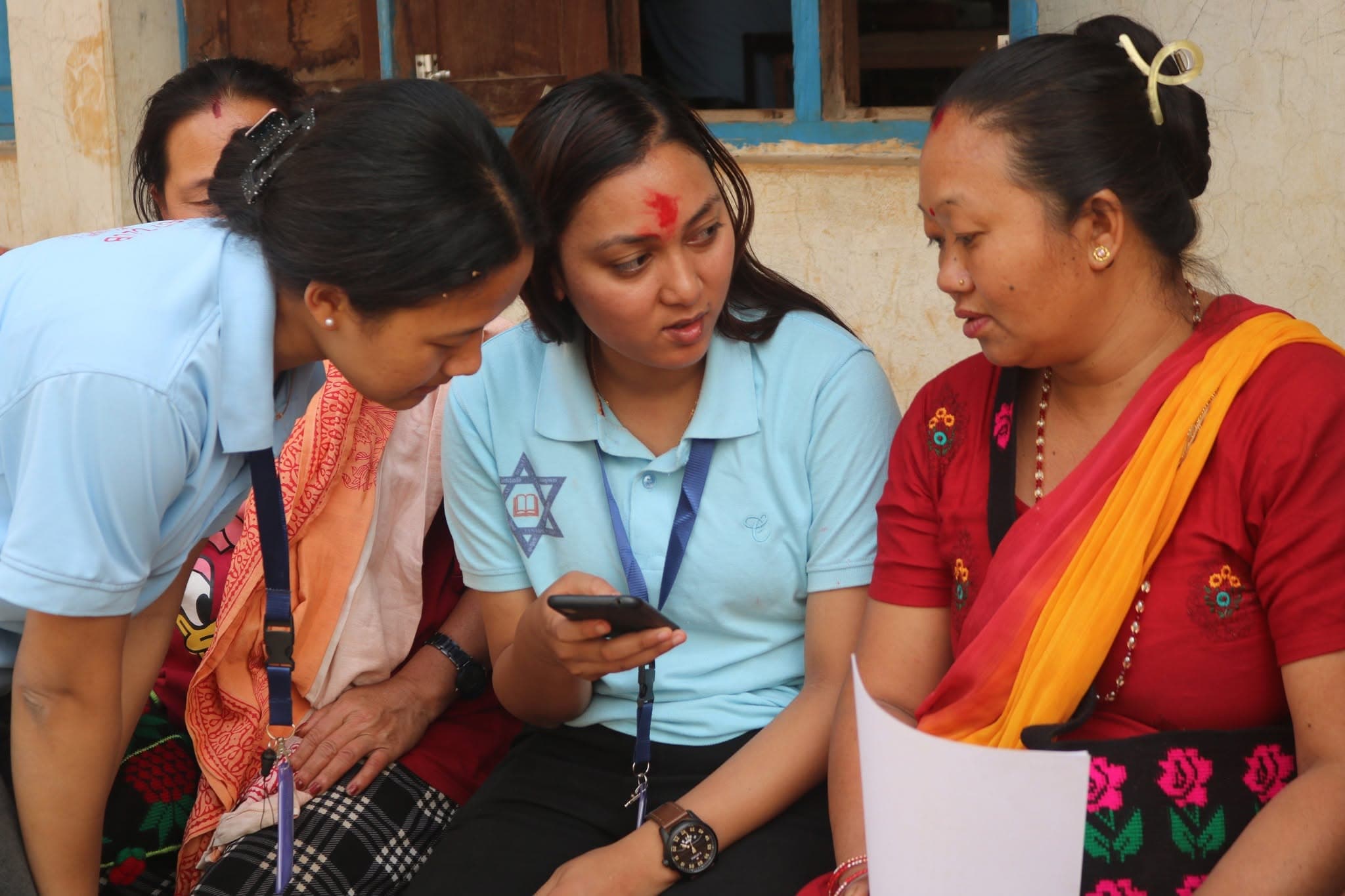 Students teaching one of the village women one to one