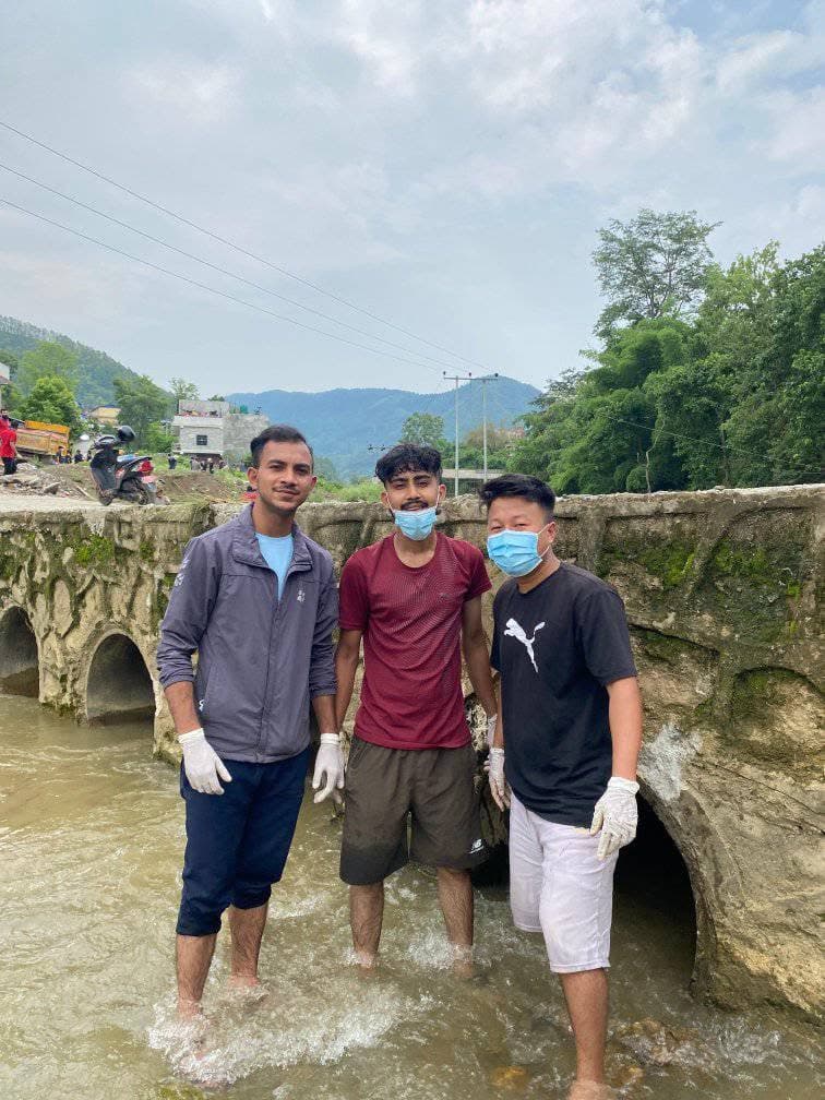 Club members working in the river near the old stone bridge