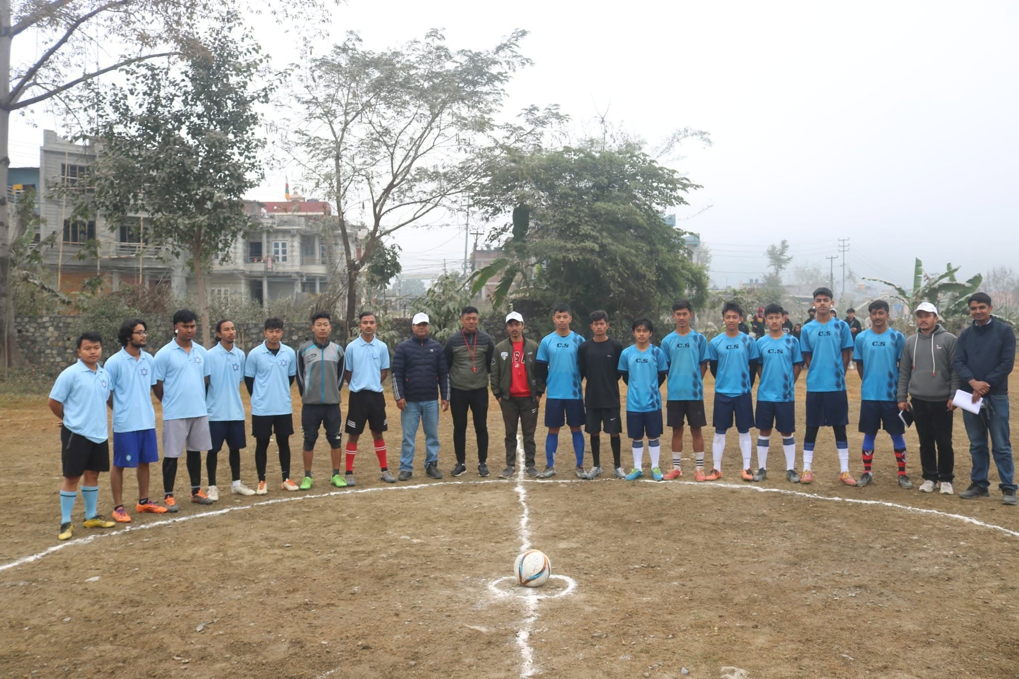 Both teams and the referee at the centre of the field